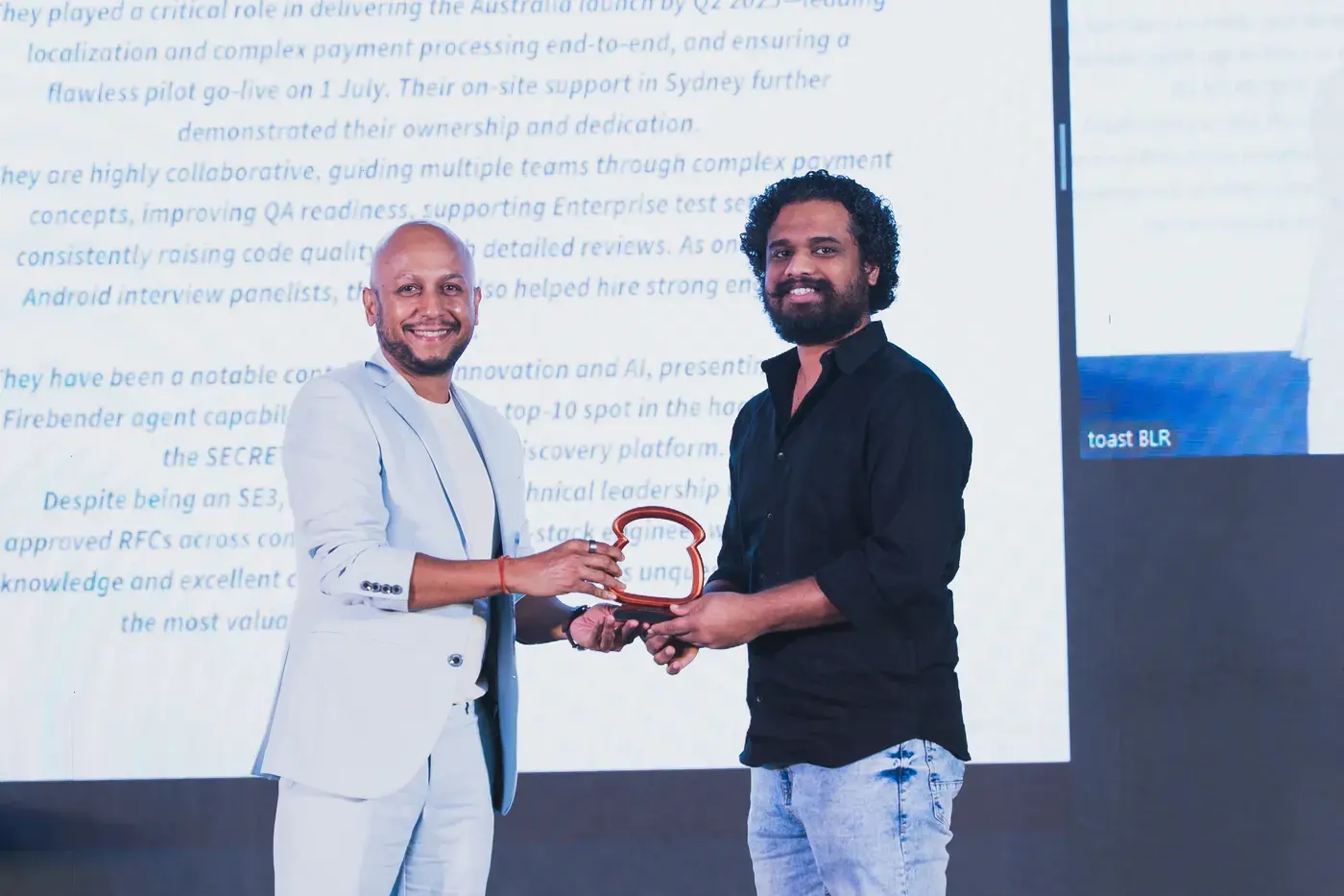 A recipient shaking hands as they take their award on stage