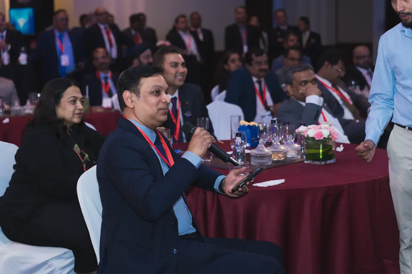 A delegate putting a question to the panel from the floor of a conference hall