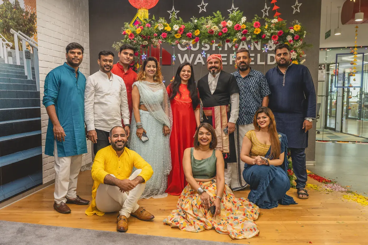 A team in festive dress posed together at a Diwali office celebration