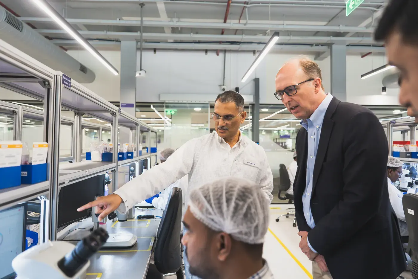 Executives touring a cleanroom production floor at a plant opening