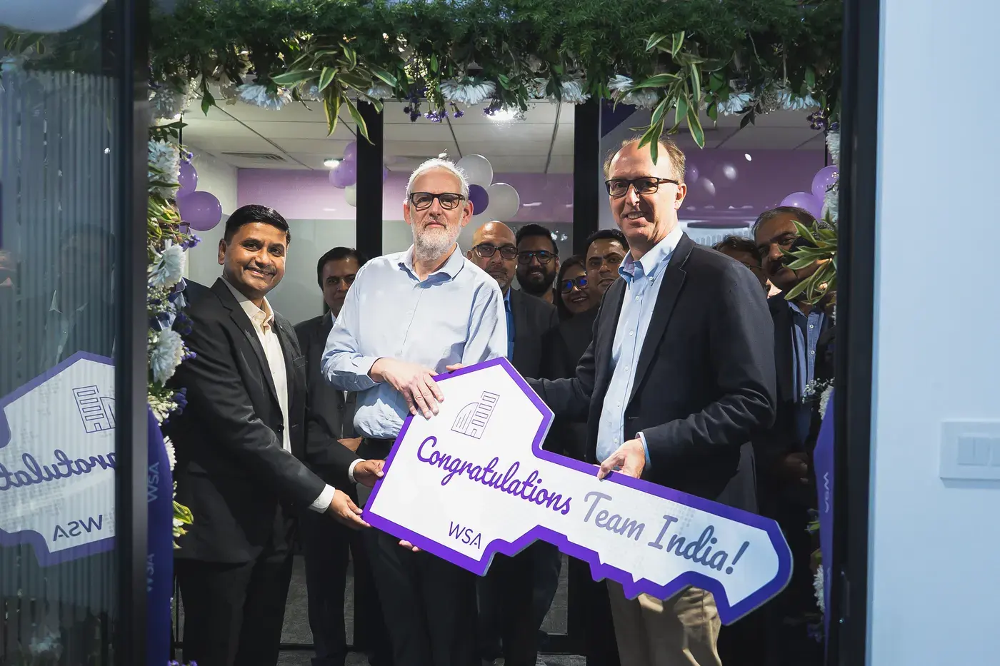 A team holding an oversized commemorative key at a site launch